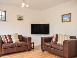 A living room with sofas and a television at Kernyk in Camelford