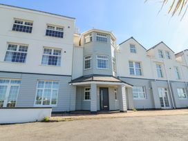 Exterior view of a multi-story residential building with multiple windows and a central entrance at Beach Court Hideaway in Trearddur Bay