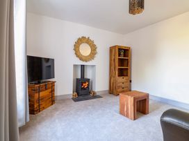 A living room with a fireplace and television at The Farmhouse in Oswestry