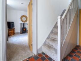 A hallway with a staircase and a view of a living room at The Farmhouse in Oswestry