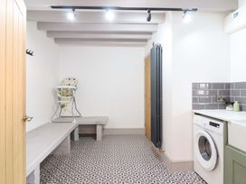 A utility room with a high chair and washing machine at The Farmhouse in Oswestry