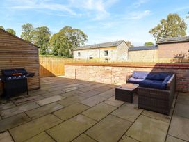 A garden with a patio and seating area at The Farmhouse in Oswestry