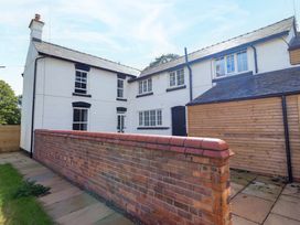 An outdoor view of a house with a brick wall at The Farmhouse in Oswestry