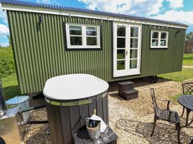A tiny house with a hot tub and outdoor seating at Bluebell in Grimsby