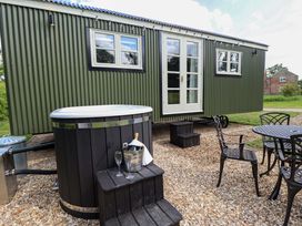 An outdoor area with a hot tub and seating table at Bluebell in Grimsby