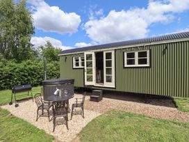 An outdoor area with a table and chairs next to a hot tub at Primrose Grimsby