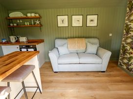 A living room with a sofa and kitchen counter at Primrose Grimsby