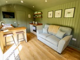 A living room with a sofa and kitchenette at Primrose in Grimsby