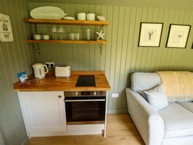A kitchen with an oven and glassware on shelves at Primrose in Grimsby