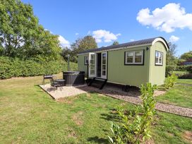 A shepherd hut with hot tub and outdoor seating at Snowdrop in Grimsby