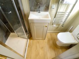 A bathroom with a shower, sink, and toilet at Snowdrop in Grimsby