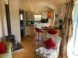 A kitchen with a stove and bar stools at Stargazy Skies near Beacon Drive near St Agnes