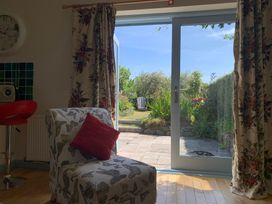 A living room with a chair and door opening to a garden at Stargazy Skies near Beacon Drive