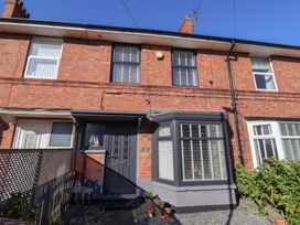 A red brick terraced house with a dark front door and bay window with white blinds at 48 Waxholme Road in Withernsea