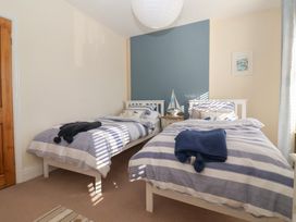 A bedroom with two single beds with striped bedding and a nightstand between them at 48 Waxholme Road in Withernsea