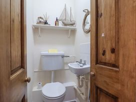 A small bathroom with a toilet and sink with wooden doors at 48 Waxholme Road in Withernsea