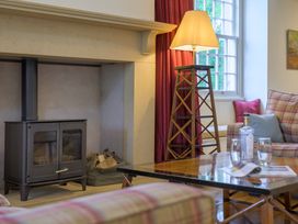 A living room with a fireplace and sofa at The School in Mungrisdale near Caldbeck