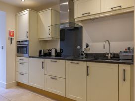 A kitchen with cabinets, a microwave, kettle, and sink at The School in Mungrisdale near Caldbeck