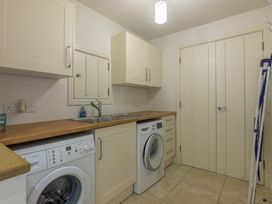 A laundry room with a washing machine, dryer, and sink at The School in Mungrisdale near Caldbeck