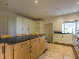 A kitchen with an island and stools at The School in Mungrisdale near Caldbeck