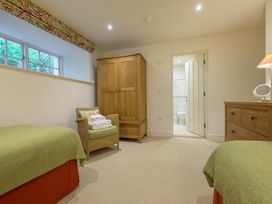 A bedroom with two beds and a wardrobe at The School in Mungrisdale near Caldbeck
