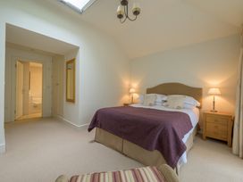 A bedroom featuring a bed, nightstand, and a door leading to a bathroom at The School in Mungrisdale near Caldbeck