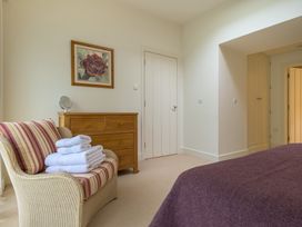 A bedroom with a bed and a chair at The School in Mungrisdale near Caldbeck