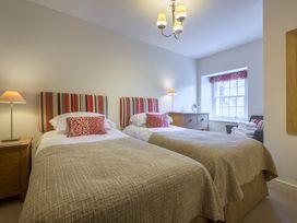 A bedroom with two twin beds and a window at The School in Mungrisdale near Caldbeck