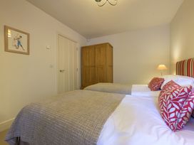 A bedroom with two beds and a wardrobe at The School in Mungrisdale near Caldbeck