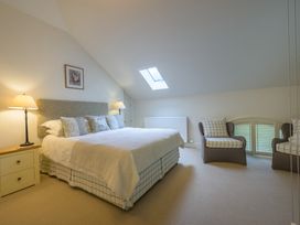 A bedroom with a bed and chairs at The School in Mungrisdale near Caldbeck