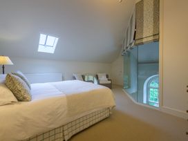 A bedroom with a bed and chair at The School in Mungrisdale near Caldbeck