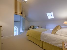 A bedroom with a bed and chairs at The School in Mungrisdale near Caldbeck