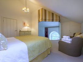 A bedroom with a bed and chair at The School in Mungrisdale near Caldbeck