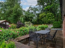 A garden with a table and chairs surrounded by flowers at The School in Mungrisdale near Caldbeck