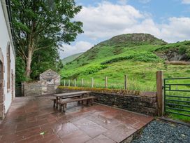 An outdoor patio with a picnic table and a stone building at The School in Mungrisdale near Caldbeck