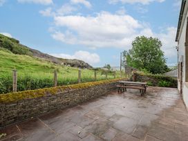 An outdoor area with a table and stone wall at The School in Mungrisdale near Caldbeck