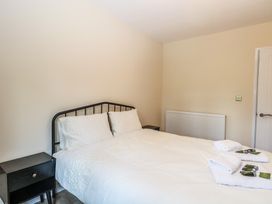 A bedroom with a bed and nightstand at Barn Owl Lodge