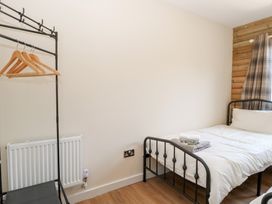 A bedroom with a bed and a clothing rack at Barn Owl Lodge