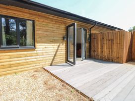 An outdoor area with wooden wall and deck at Barn Owl Lodge