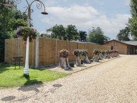 An outdoor glamping area with flower planters and a wooden fence at Barn Owl Lodge