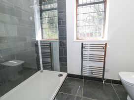A bathroom with a shower area a window and a towel radiator at Bwthyn y Coediwr The Woodcutters Cottage in Tan Y Bwlch Maentwrog