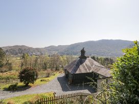 A cottage with a chimney surrounded by trees and hills at Bwthyn y Coediwr The Woodcutters Cottage in Tan Y Bwlch Maentwrog