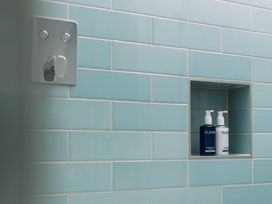 A bathroom with blue tiles and soap dispensers at Trevean in Mullion