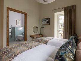 A bedroom with two beds and an en-suite bathroom at Trevean in Mullion