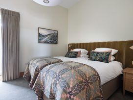 A bedroom with twin beds and a bedside table at Trevean in Mullion