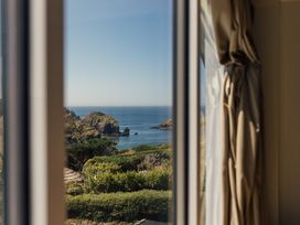 A view of the sea and garden through a window at Trevean in Mullion
