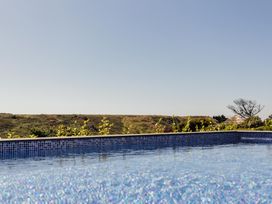 A swimming pool with water and landscape at Trevean in Mullion