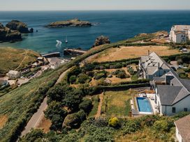 An aerial view of the coastline with a harbor and houses at Trevean in Mullion