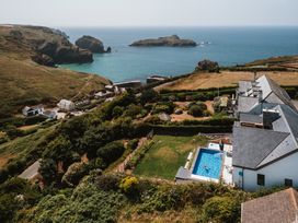 A view of a pool and garden by the sea at Trevean in Mullion