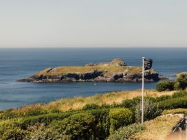 A view of an island and ocean with greenery at Trevean in Mullion
